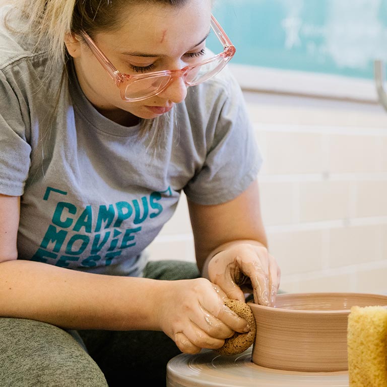 A person works at a pottery wheel.