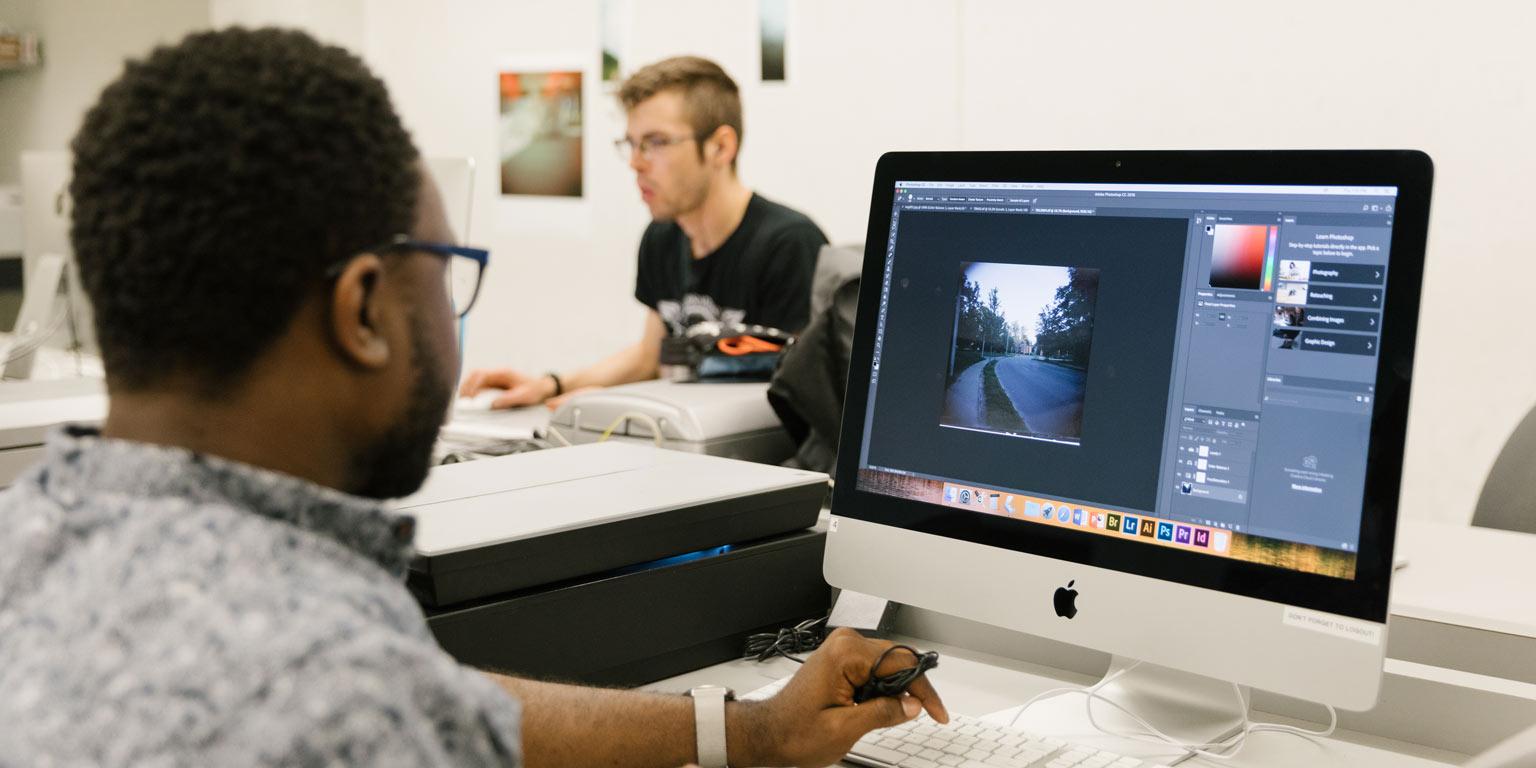 Two students work on their computers.