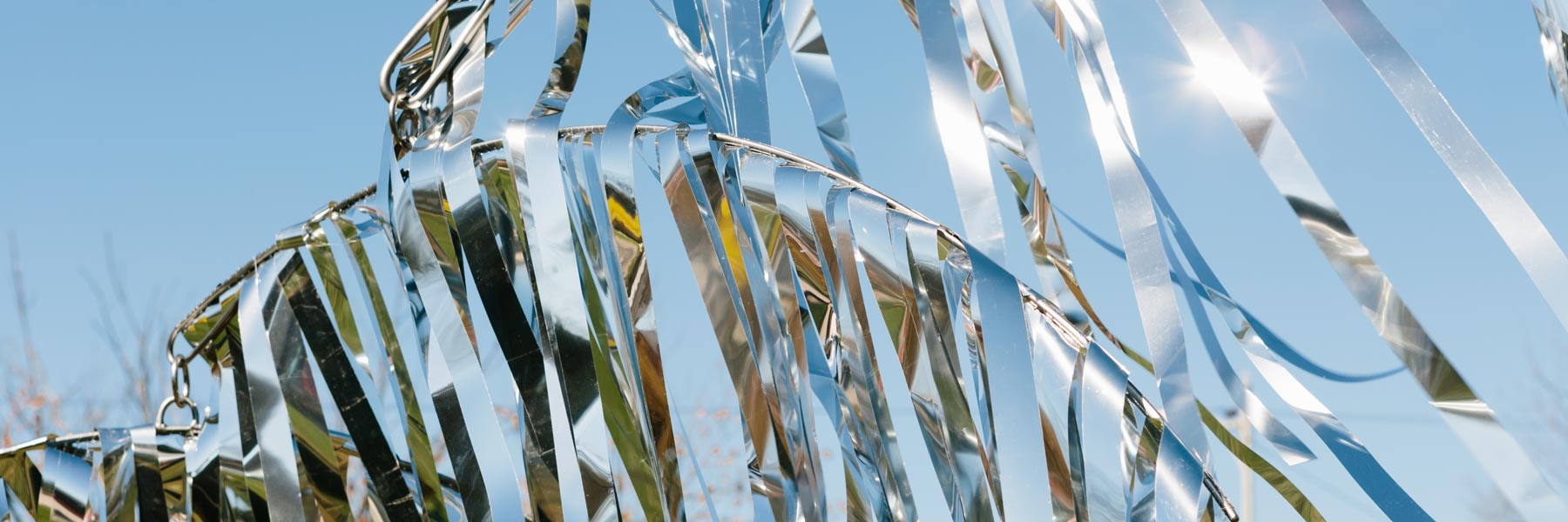 A silver sculpture against a blue sky.
