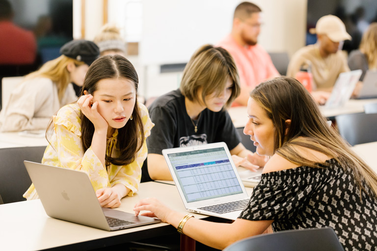 Two students work together at a computer.