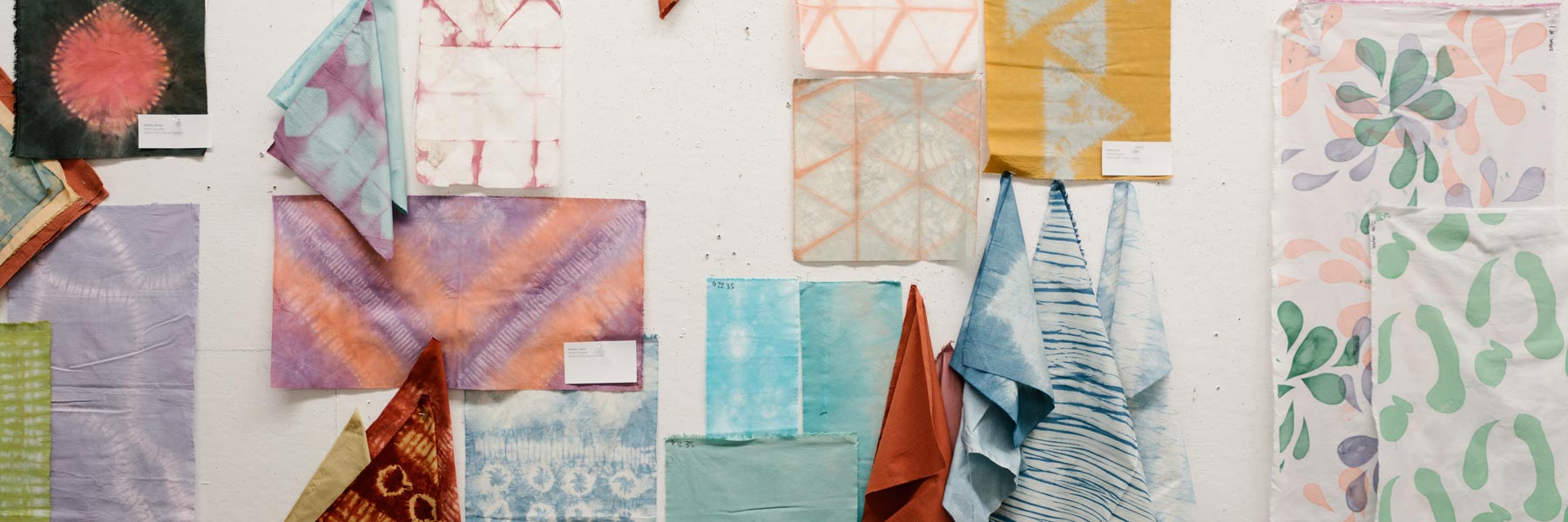 Textile samples pinned on the wall.