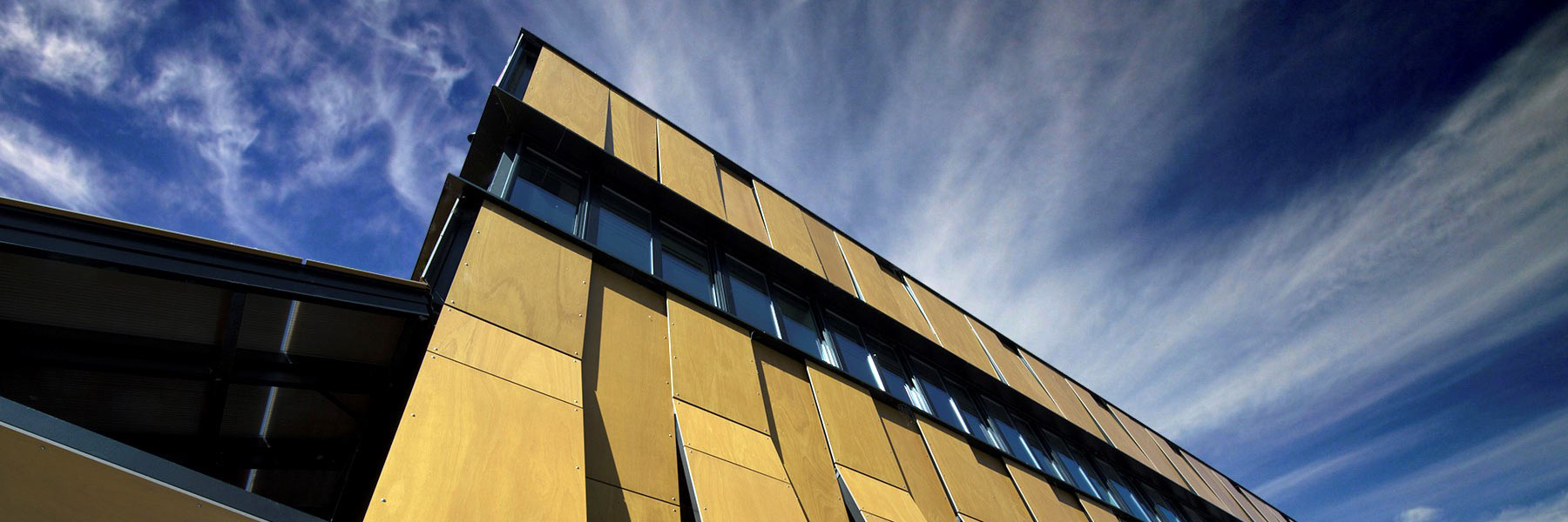 A tall building against a blue sky with clouds.