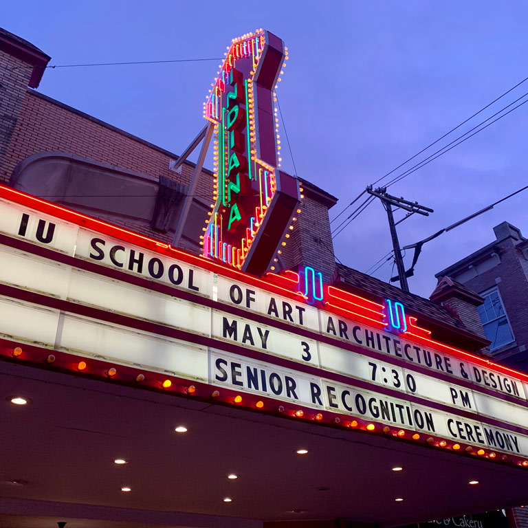 A marquee in front of a theater lit up at night.