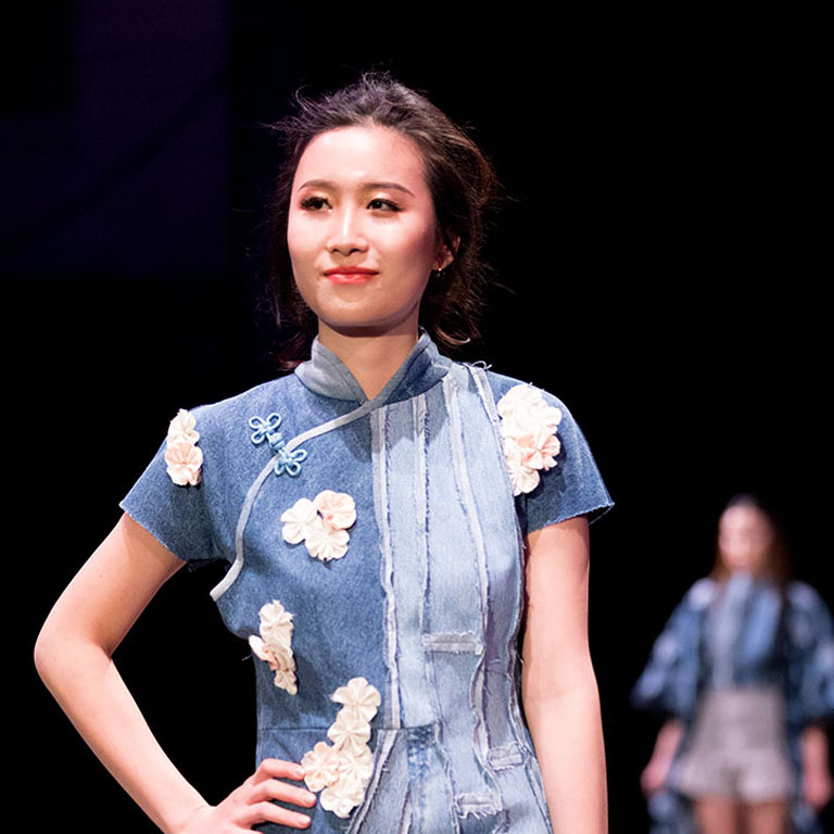 a person poses on a runway.