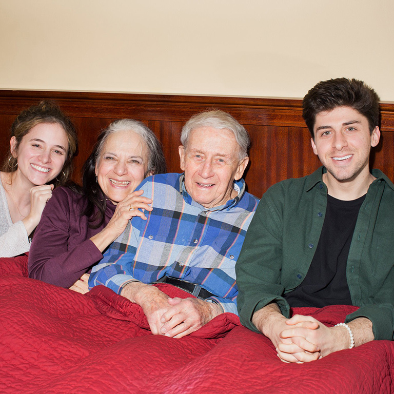 Four people smile at the camera