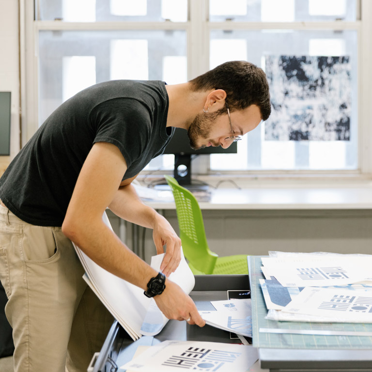 A person puts artwork in a flat file.